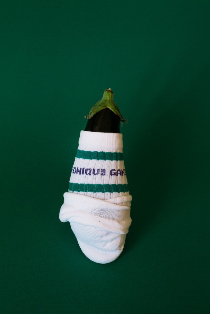 photo d'une aubergine dans une chaussette, sur un fond vert